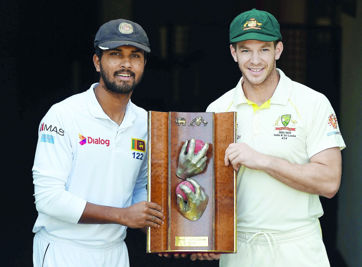 Sri Lanka's captain Dinesh Chandimal (L) and Australia's captain Tim Paine pose with the Warne-Murali Test trophy at The Gabba in Brisbane on January 23, 2019, ahead of their first day-night Test match between Australia and Sri Lanka on January 24. AFP / 