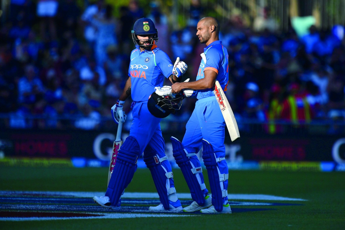 India's captain Virat Kohli (L) walks from the field with teammate Shikhar Dhawan after the sun angle halted play during the first one-day international (ODI) cricket match between New Zealand and India at McLean Park in Napier on January 23, 2019.  AFP /