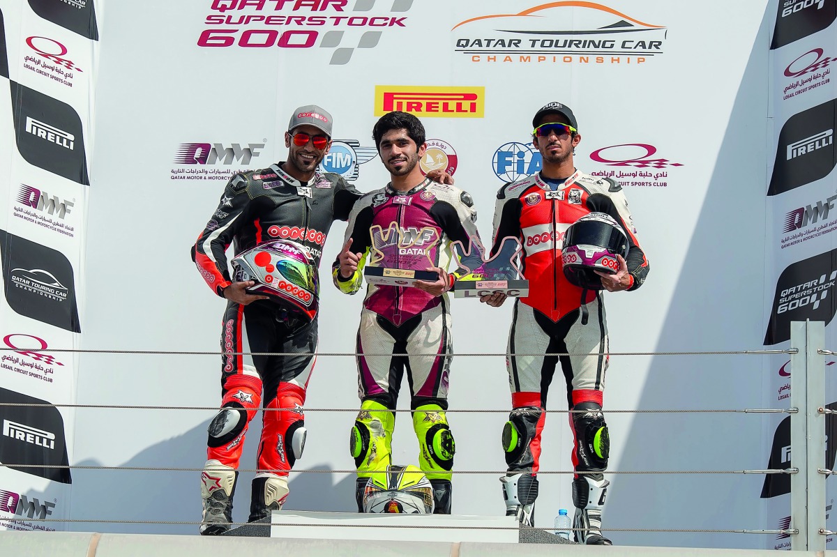 Abdullah Al Qubaisi (centre), Saeed Al Sulaiti (left) and Mishal Al Naimi pose on the podium after a Qatar Superstock 600 Championship race at Losail International Circuit, yesterday. RIGHT: Al Qubaisi celebrates his victory.  