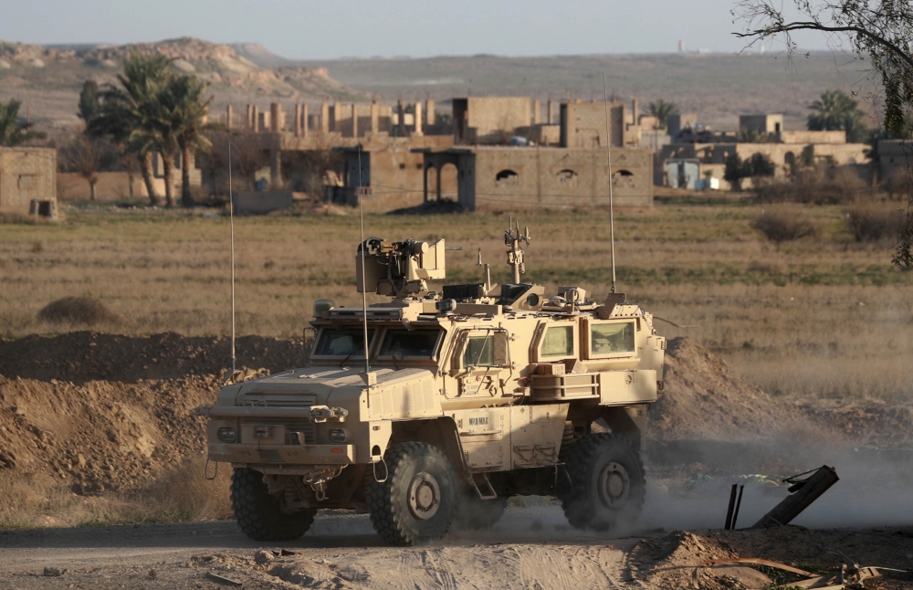 A US military vehicle drives through the Syrian village of Baghuz in the countryside of the eastern Deir Ezzor province on January 26, 2019.  AFP / DELIL SOULEIMAN
