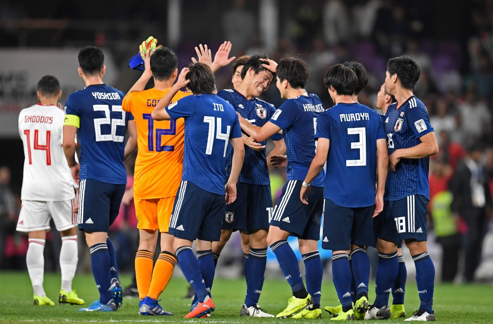 Japan's players celebrate their victory during the 2019 AFC Asian Cup semi-final football match between Iran and Japan at the Hazza Bin Zayed Stadium in Abu Dhabi on January 28, 2019. / AFP / Khaled DESOUKI