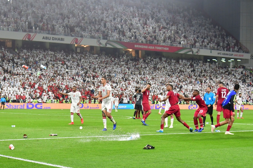 Fans throw bottles and flip-flops at the pitch during the 2019 AFC Asian Cup semi-final football match between Qatar and UAE at the Mohammed Bin Zayed Stadium in Abu Dhabi on January 29, 2019. AFP / Giuseppe Cacace