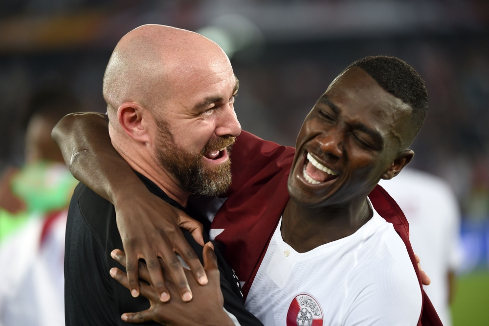 Qatar's forward Almoez Ali (R) celebrates with Qatar's coach Felix Sanchez after winning the 2019 AFC Asian Cup final football match between Japan and Qatar at the Mohammed Bin Zayed Stadium in Abu Dhabi on February 1, 2019. / AFP / Roslan RAHMAN
