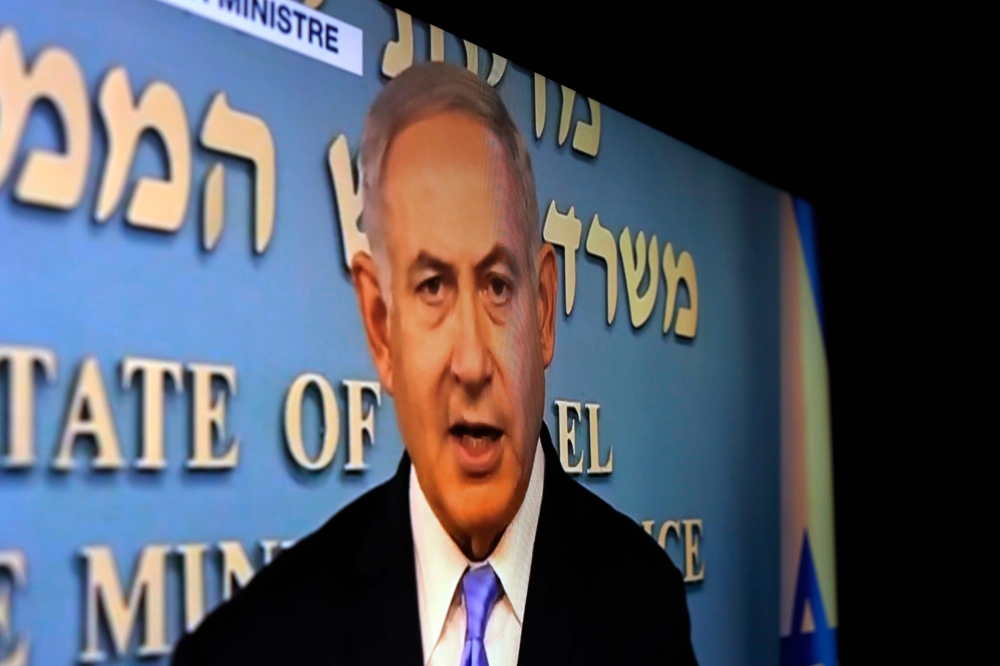 TV screen shows Israeli Prime Minister Benjamin Netanyahu delivering a speech on May 8, 2018. AFP/Thomas Coex