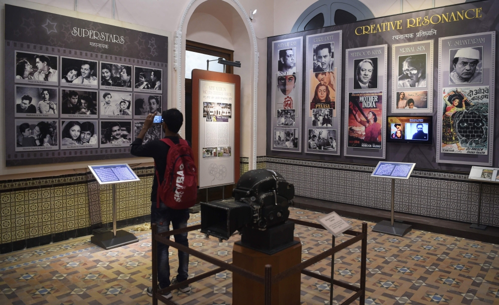 In this picture taken on January 22, 2019, a student takes a picture of a display with images of former Indian movie actors at the National Museum of Indian Cinema (NMIC), the country's first museum showcasing the history of its film industry, in Mumbai. 