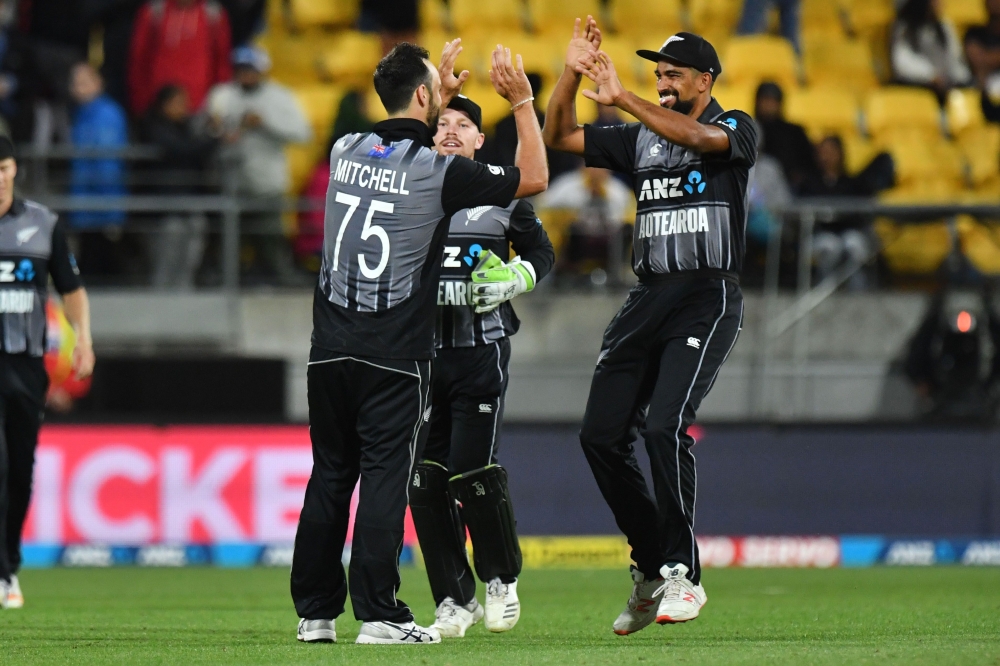 New Zealand's Ish Sodhi (R) with teammates Tim Seifert (C) and Daryl Mitchell (L) celebrate their win in the first Twenty20 cricket match between New Zealand and India in Wellington on February 6, 2019. / AFP / Marty MELVILLE