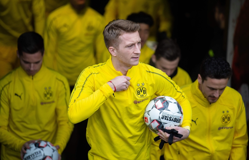 Dortmund's German forward Marco Reus carries the ball as he and his teammates come out to warm up prior the German First division Bundesliga football match between Eintracht Frankfurt v BVB Borussia Dortmund, in Frankfurt on February 2, 2019. AFP / / Sila