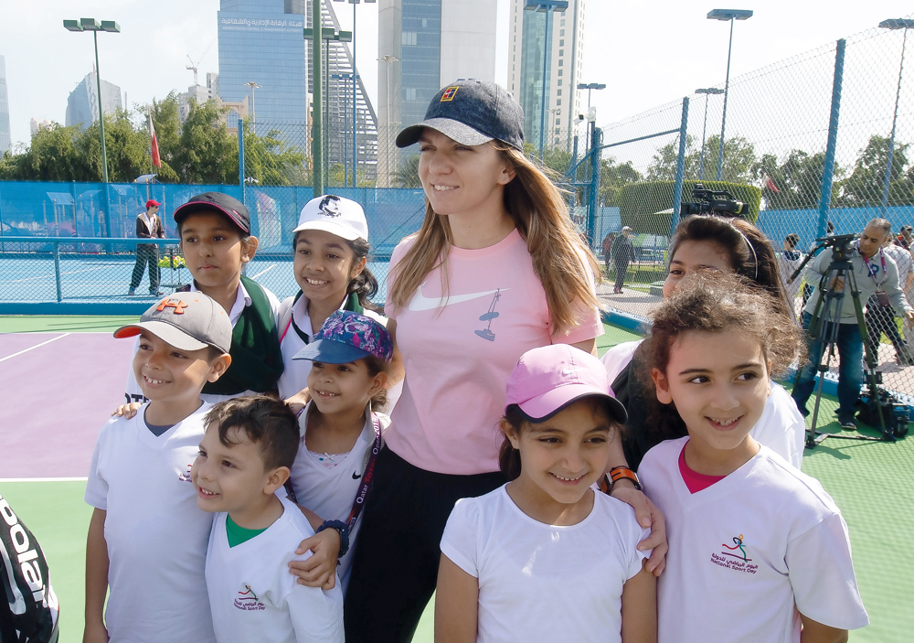 Simona Halep poses for a picture along with young fans as she attends the National Sport Day related event at Khalifa International Tennis Complex, yesterday.  