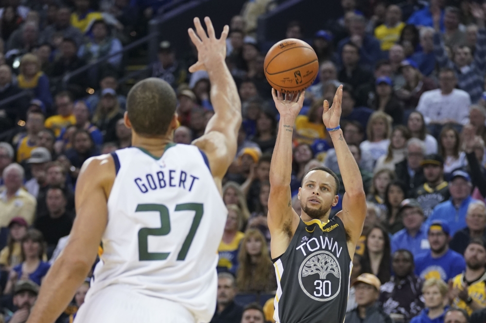 Golden State Warriors guard Stephen Curry (30) shoots the basketball against Utah Jazz center Rudy Gobert (27) during the second quarter at Oracle Arena. Kyle Terada 

