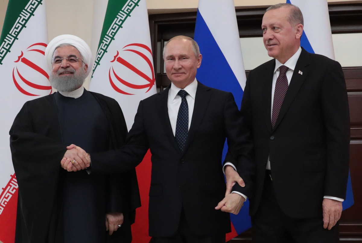 A handout picture taken and released on February 14, 2019 by the Turkish Presidential Press service shows Iranian President Hassan Rouhani (L), Russian President Vladimir Putin (C) and Turkish President Recep Tayyip Erdogan (R) posing for photographers du