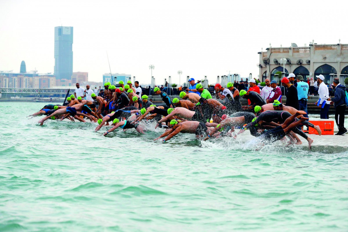 Swimmers dive into Corniche water during the Doha Open Water Challenge yesterday. 
