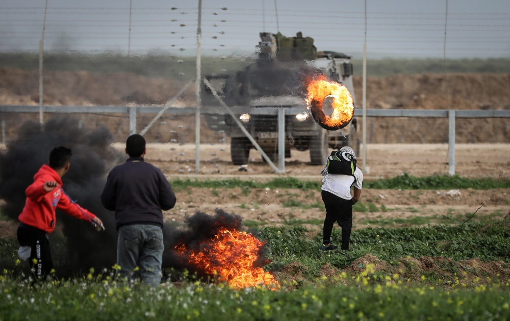 Palestinians burn tyres as Israeli forces intervene them during the 