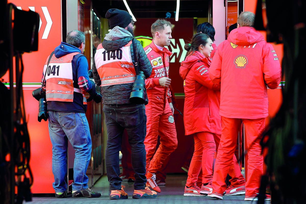 Ferrari's German driver Sebastian Vettel (C) walks in the paddock during the tests for the new Formula One Grand Prix season at the Circuit de Catalunya in Montmelo in the outskirts of Barcelona on February 18, 2019. AFP / Lluis Gene
