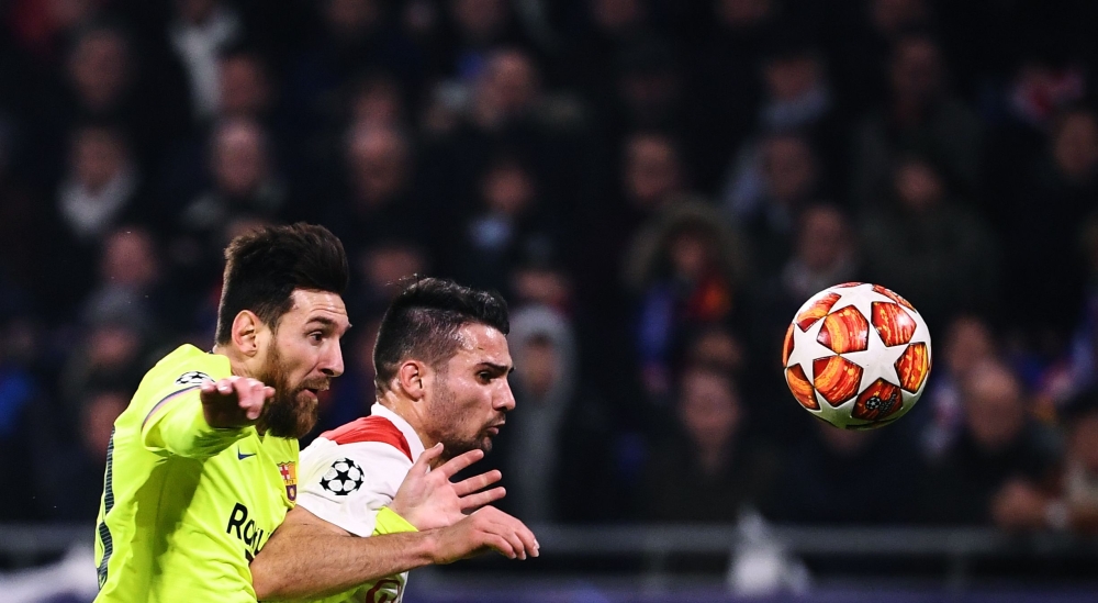 Barcelona's Argentinian forward Lionel Messi (L) and Lyon's French defender Leo Dubois (R) vies for the ball during the UEFA Champions League round of 16 first leg football match between Lyon (OL) and FC Barcelona on February 19, 2019, at the Groupama Sta