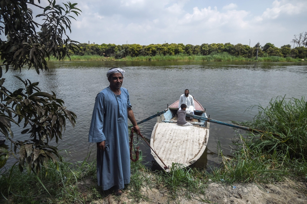 Workers in a mango farms ride a boat on a branch of the Nile after finishing their work in the Al Qata village, Giza Governorate, on August 27, 2018. AFP/Mohamed el-Shahed