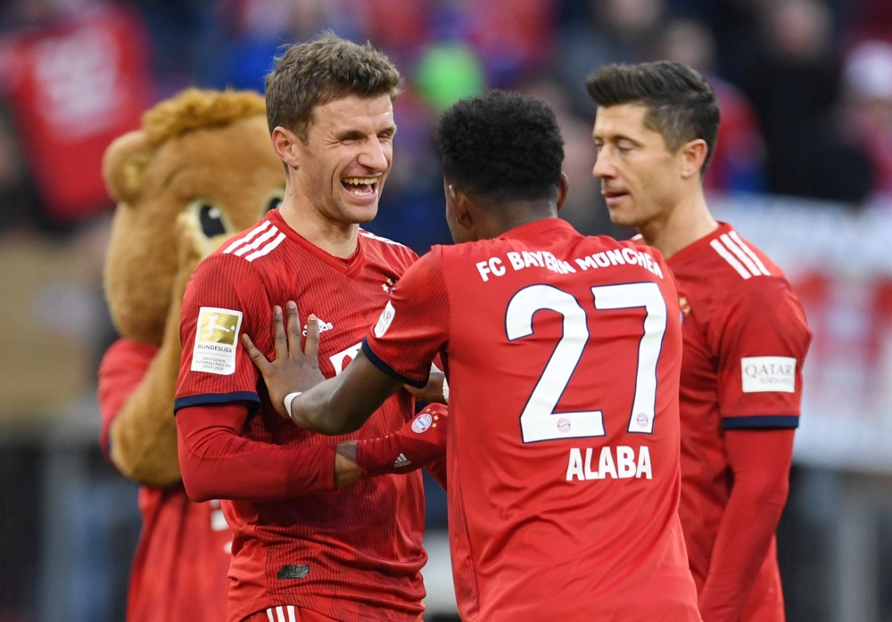 Bayern Munich's Thomas Mueller celebrates with David Alaba at the end of the match REUTERS/Andreas Gebert