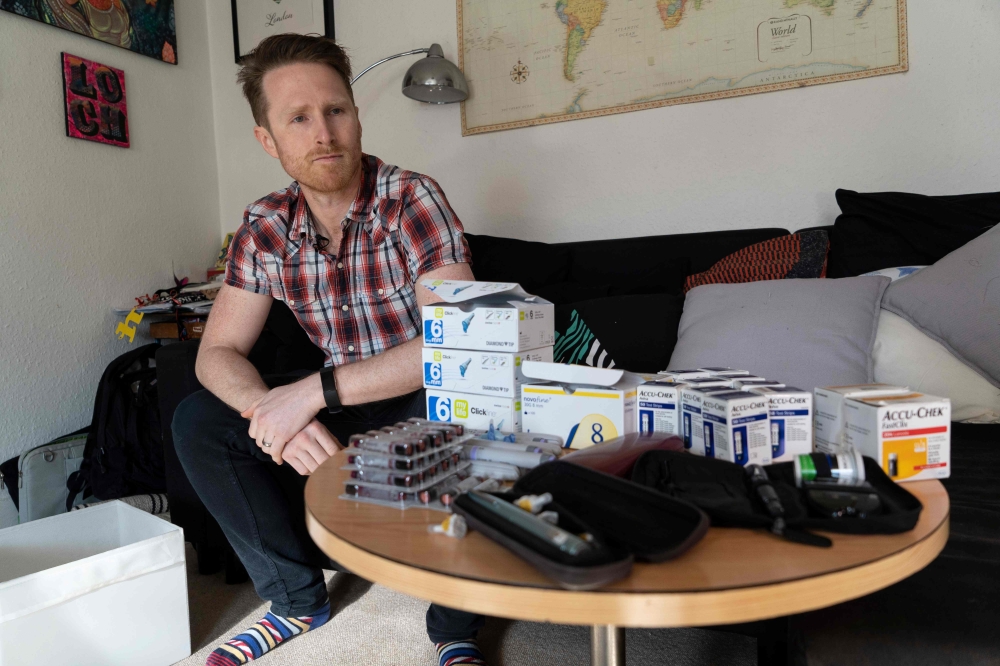 David Burns, 38, who has type 1 diabetes, poses for a prepares his insulin pen to inject himself in his home in North London on February 24, 2019. AFP / Niklas Halle'n 
