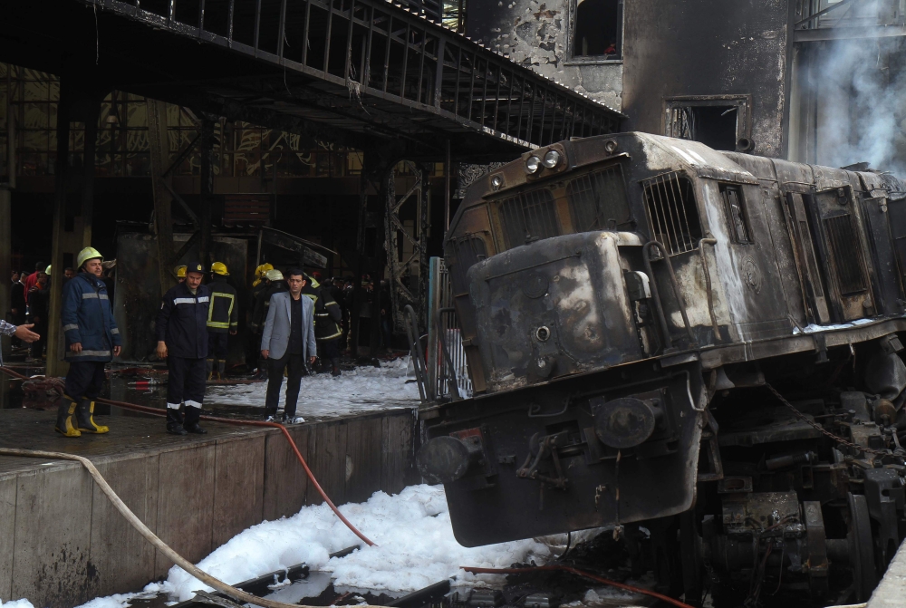 Fire fighters and onlookers gather at the scene of a fiery train crash at the Egyptian capital Cairo's main railway station on February 27, 2019.  AFP / STRINGER
