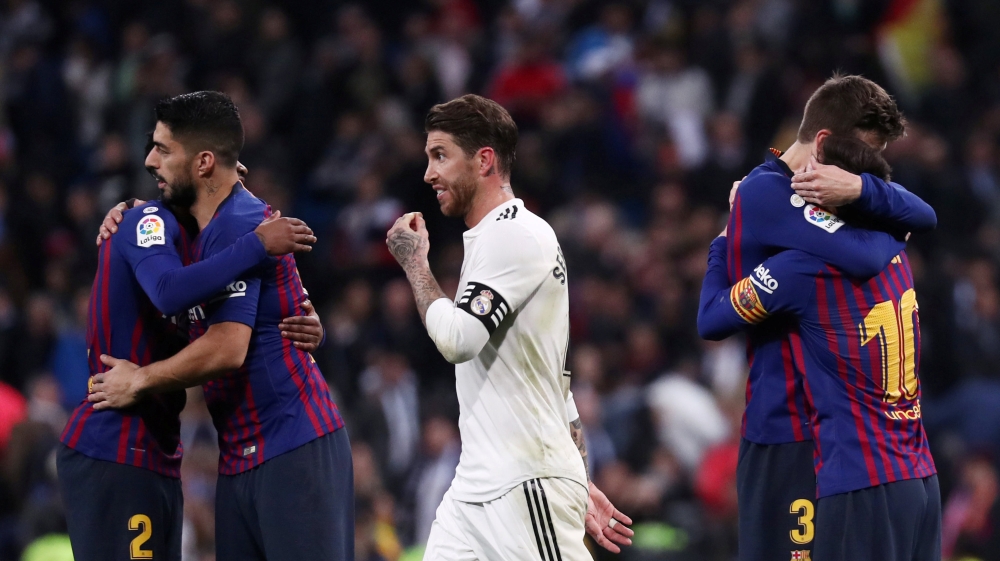 FC Barcelona's Lionel Messi, Luis Suarez and Gerard Pique celebrate victory as Real Madrid's Sergio Ramos walks off REUTERS/Sergio Perez