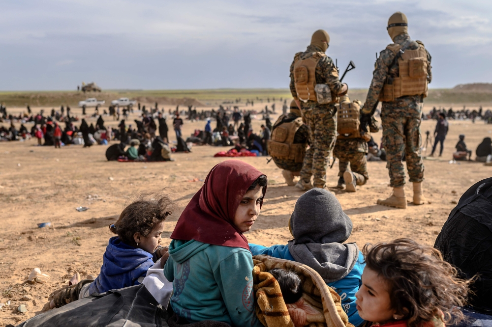 Civilians evacuated from the Islamic State (IS) group's embattled holdout of Baghouz wait at a screening area held by the US-backed Kurdish-led Syrian Democratic Forces (SDF), in the eastern Syrian province of Deir Ezzor, on March 5, 2019.   AFP / Bulent 