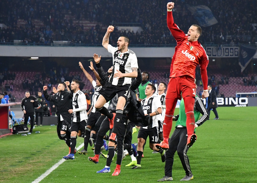 Juventus's players celebrate at the end of the Italian Serie A football match between Napoli and Juventus on March 3, 2019, at the San Paolo Stadium in Naples. / AFP / Alberto PIZZOLI
