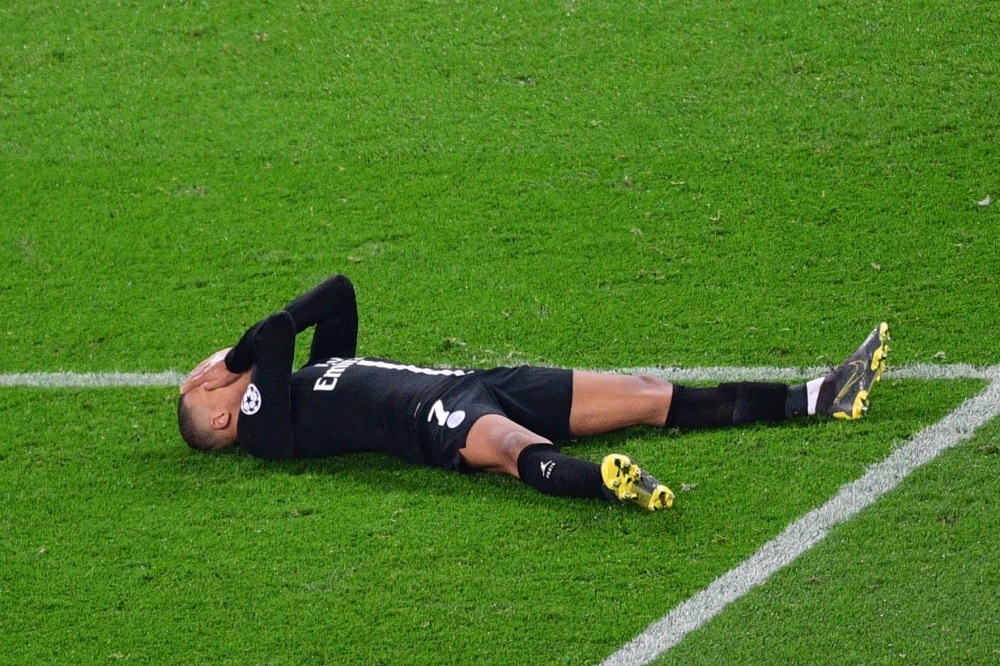 Paris Saint-Germain's French forward Kylian Mbappe reacts as he lies on the pitch at the end of the UEFA Champions League round of 16 second-leg football match between Paris Saint-Germain (PSG) and Manchester United at the Parc des Princes stadium in Pari