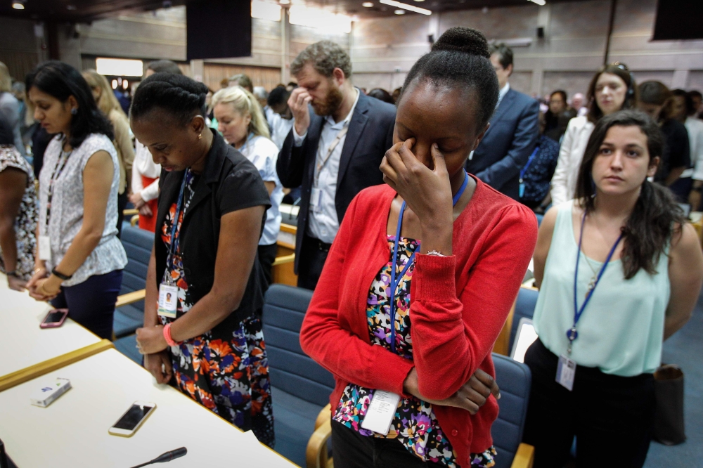 A handout photo by UNEP shows the UN Staff observing a minute of silence for the victims of the accident of the Ethiopian Airlines, including 19 UN workers, before the opening plenary of the 4th UN Environment Assembly at the UN headquaters in Nairobi, Ke
