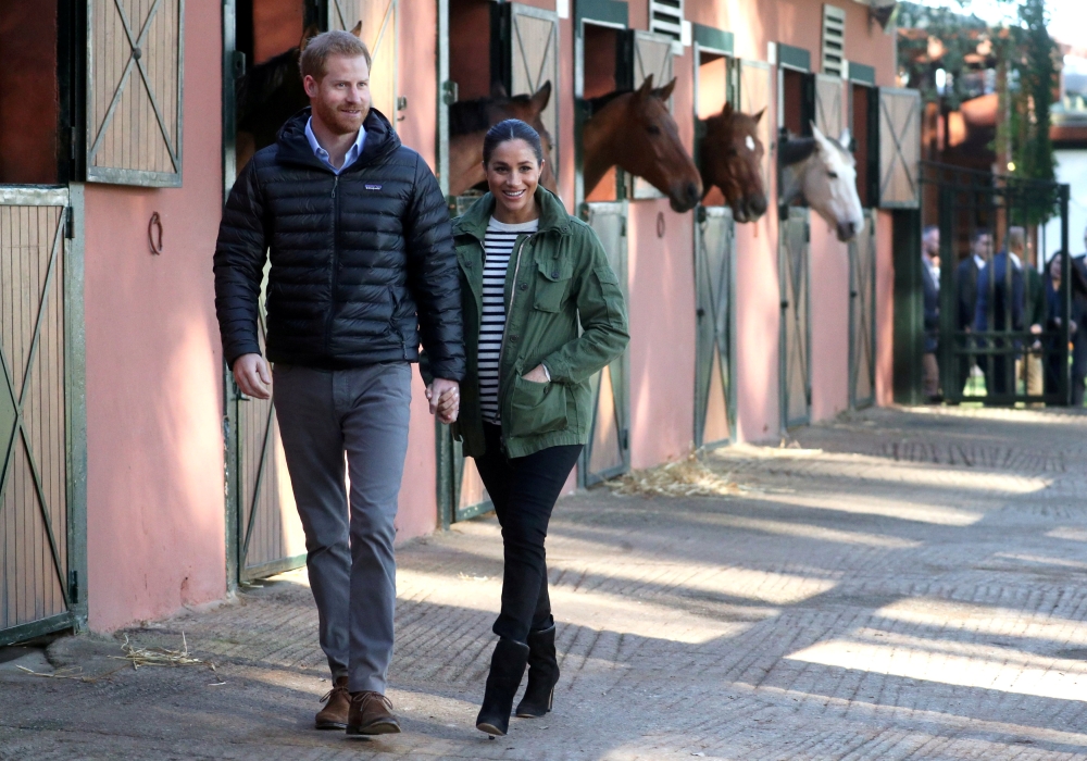 FILE PHOTO: Britain's Prince Harry and Meghan, Duchess of Sussex, visit the Moroccan Royal Federation of Equitation Sports in Rabat, Morocco, February 25, 2019. REUTERS/Hannah Mckay/Pool/File Photo