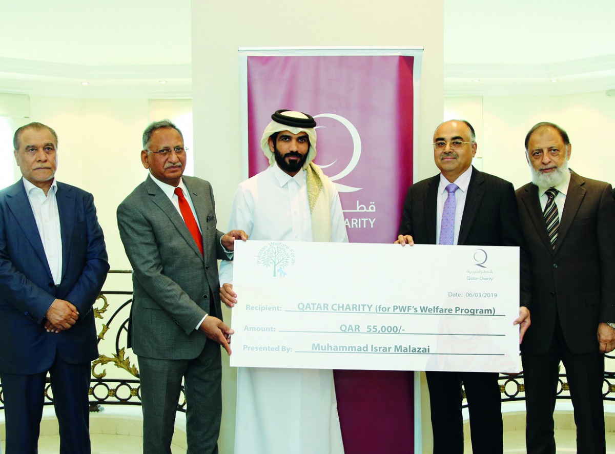 Ali Al Gharib, Director of Programs and Public Relations Department at Qatar Charity, receiving donation from the Pakistani businesspersons in the presence of Ahmed Hussein, President of the Pakistan Welfare Forum, and other members.