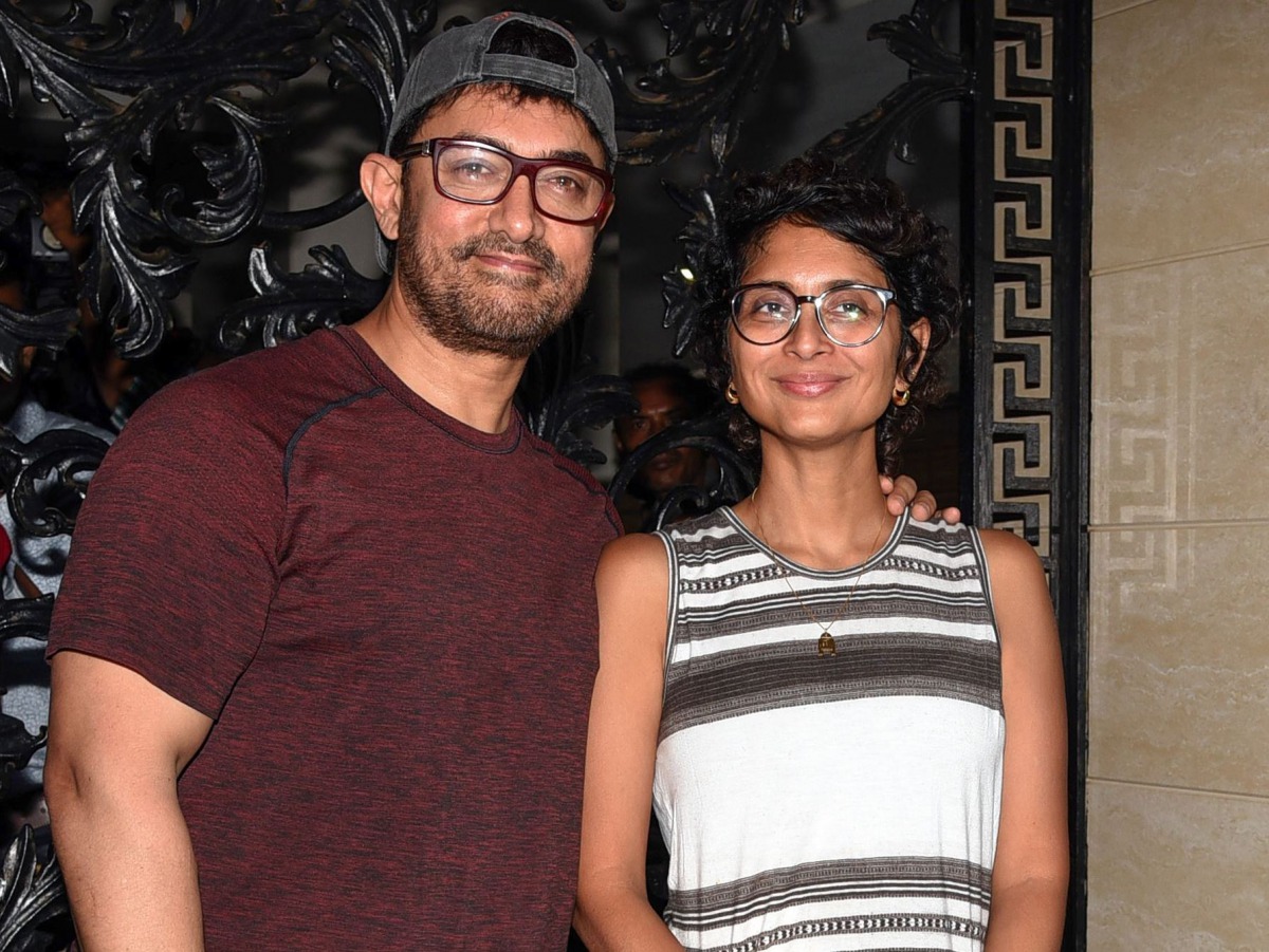 Indian Bollywood actor and producer Aamir Khan (L) along with his wife, film director and screenwriter Kiran Rao Khan (R), pose for photographs on his 54th birthday at his residence in Mumbai on March 14, 2019. / AFP / STR