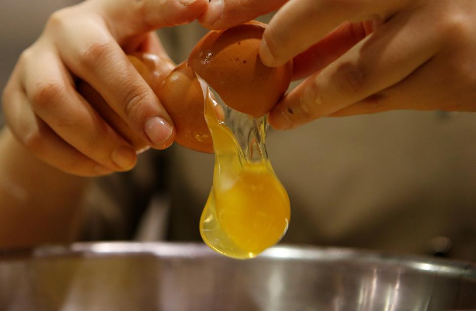 A pastry chef breaks an egg as she prepares to bake a cake at a bakery in Seoul, December 22, 2016. Reuters/Kim Hong-Ji