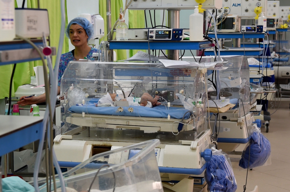 A photo taken March 11, 2019, shows a nurse checking on babies inside incubators at the maternity ward of the Rabta hospital in Tunis.  AFP / Fethi Belaid 