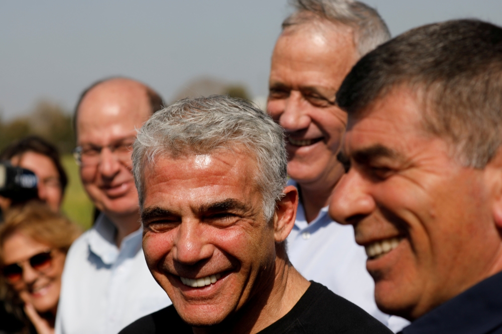 Blue and White party head Benny Gantz stands next to fellow party candidates during a visit to a kibbutz in Israel outside the northern Gaza Strip, March 13, 2019. Reuters/Amir Cohen
