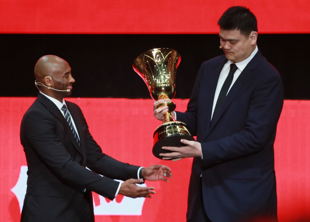 Former NBA star Yao Ming (R) is presented with a trophy by former NBA star Kobe Bryant during the draw ceremony for the 2019 FIBA Basketball World Cup, in Shenzhen, in China's southern Guangdong province on March 16, 2019.  China OUT / AFP / STR