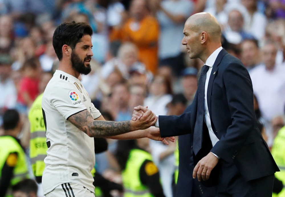 Real Madrid's Isco shakes hands with coach Zinedine Zidane REUTERS/Susana Vera