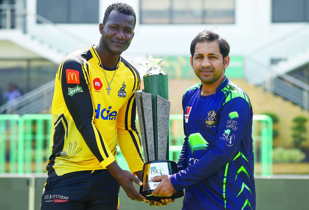 Peshawar Zalmi’s captain Daren Sammy (left) and Pakistani captain of Quetta Gladiators cricket team, Sarfraz Ahmed pose for a photograph with the Pakistan Super League Trophy at the National Cricket Stadium in Karachi, yesterday.