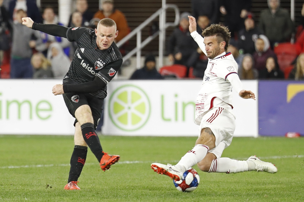 Washington, DC, USA; D.C. United forward Wayne Rooney (9) shoots the ball as Real Salt Lake midfielder Kyle Beckerman (5) defends in the second half at Audi Field. D.C. United won 5-0. Geoff Burke