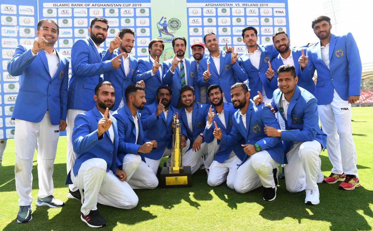 Afghanistan's team members pose with the trophy after winning the Test cricket match between Afghanistan and Ireland at the Rajiv Gandhi International Cricket Stadium in the northern Indian city of Dehradun on March 18, 2019. AFP / Money Sharma