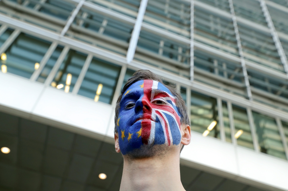 A man with painted EU and British flags on his face is seen ahead of a EU Summit in front of European Commission headquarters in Brussels, Belgium March 21, 2019. REUTERS/Yves Herman