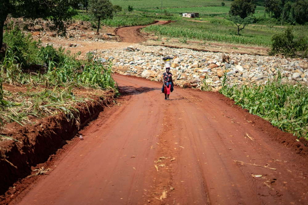 A woman walks on a road near a damaged bridge in Chimanimani as efforts to restore damaged road transport services are intensified, on March 22, 2019. AFP / Zinyange AUNTONY