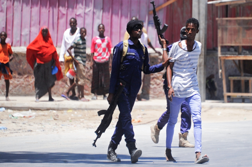 Somali soldiers arrest a civilian close to the scene of two explosions set off near the ministries of public works and labour in Mogadishu on March 23, 2019. AFP / MOHAMED ABDIWAHAB