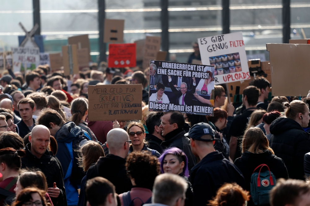 People hold placards during a demonstration under the slogan 