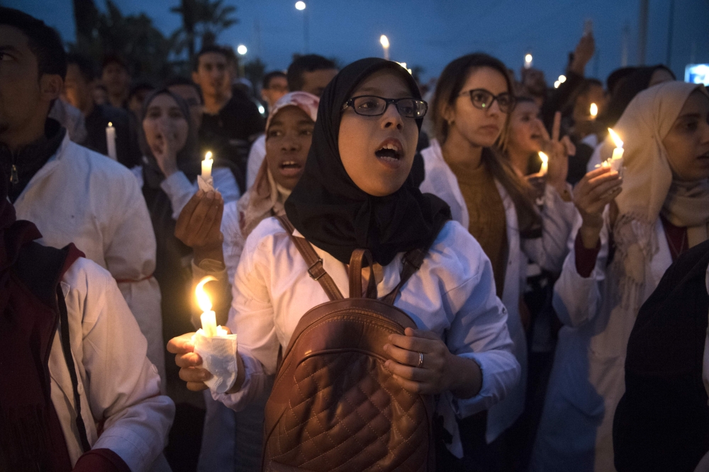 Young Moroccan school teachers hold candles as they protest against their current status in the capital Rabat on March 24, 2019. AFP / FADEL SENNA