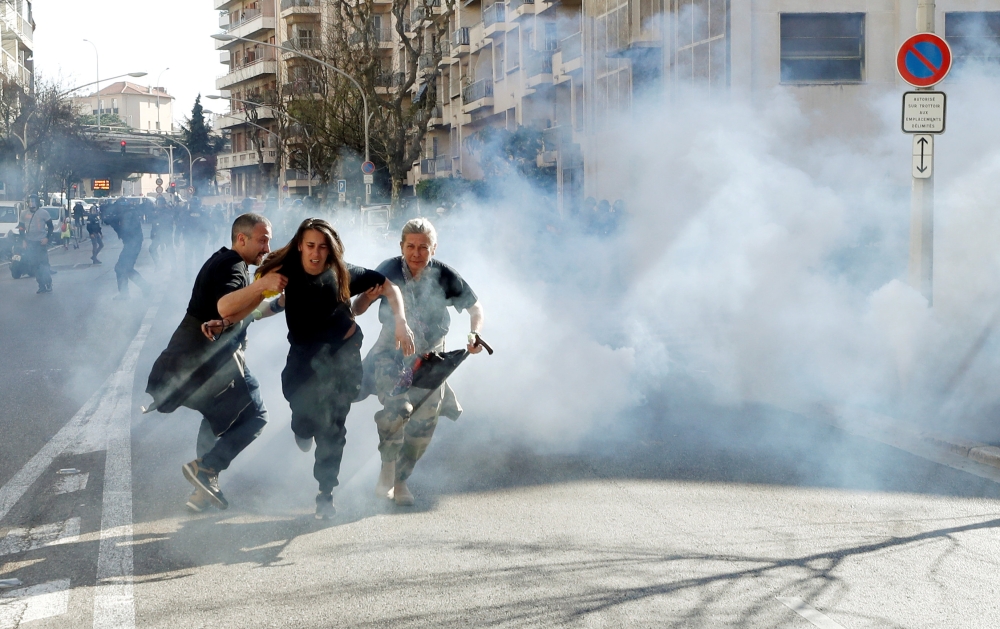 Protesters run away as tear gas is fired during 19th round of 