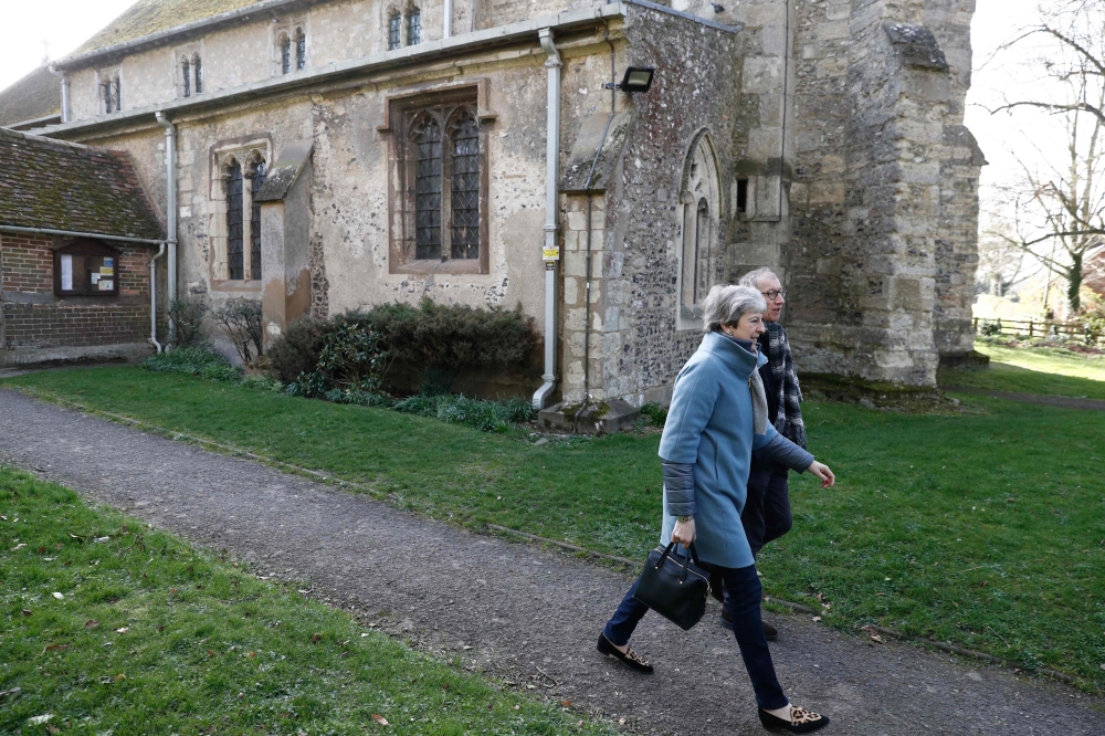 Britain's Prime Minister Theresa May (L) leaves with her husband Philip (R) after attending a church service, near her Maidenhead constituency, west of London on March 24, 2019.  AFP / Adrian DENNIS