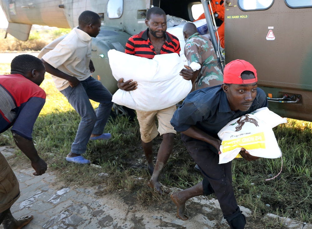 Workers offload food aid from a South African National Defence Force helicopter in the aftermath of Cyclone Idai in Buzi, near Beira, Mozambique, March 25, 2019. Reuters/Mike Hutchings