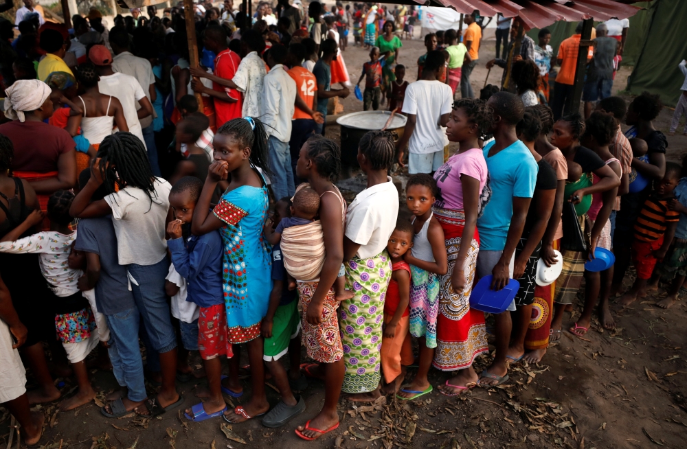 People queue for food in a camp for those displaced in the aftermath of Cyclone Idai in Beira, Mozambique, March 26, 2019. Picture taken March 26, 2019. REUTERS/Mike Hutchings