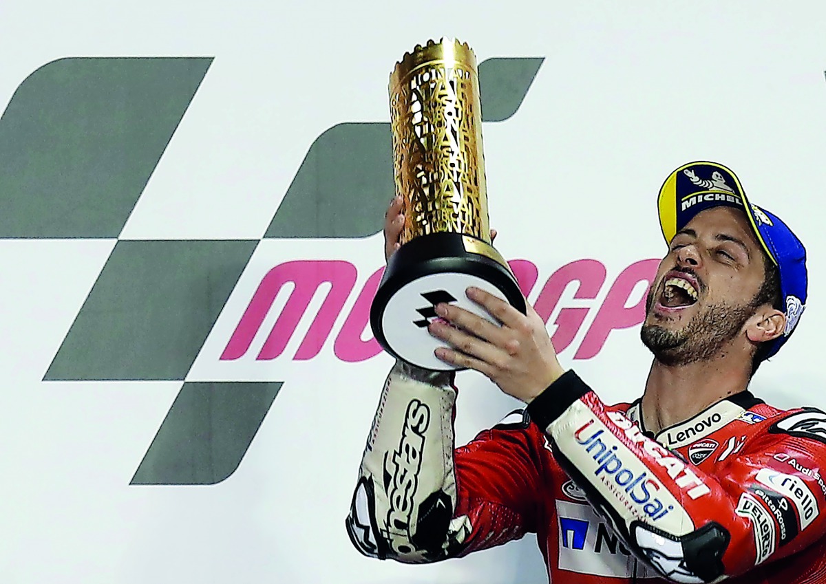 Mission Winnow Ducati’s Andrea Dovizioso celebrates with a trophy on the podium after winning the MotoGP race during the VisitQatar Grand Prix at the Losail International Circuit.