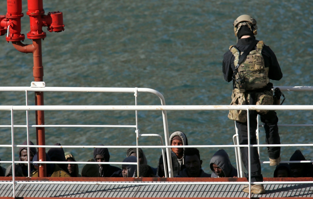 A Maltese special forces soldier guards a group of migrants on the merchant ship Elhiblu 1 after it arrived in Senglea, in Valletta's Grand Harbour, Malta, March 28, 2019. REUTERS/Darrin Zammit Lupi