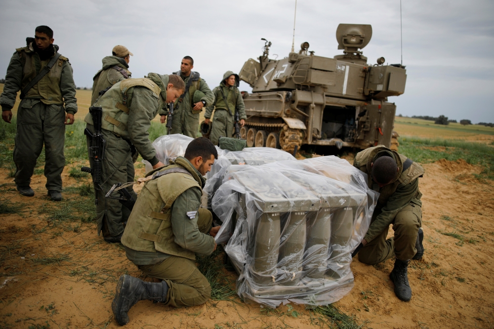Israeli soldiers cover shells next to a mobile cannon near the border with Gaza, in southern Israel March 29, 2019. Reuters/Amir Cohen